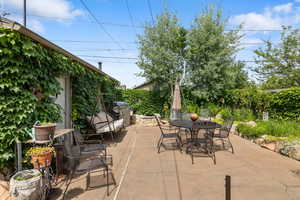 View of patio with outdoor dining area and a grill