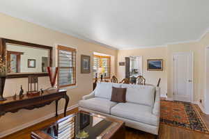 Living room with dark wood finished floors and crown molding