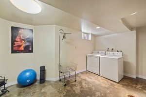 Washroom with washing machine and clothes dryer and baseboards