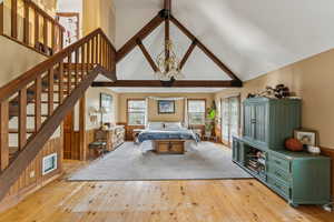 Bedroom with light wood-style flooring and high vaulted ceiling