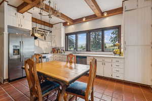 Dining area featuring beamed ceiling and tile patterned flooring