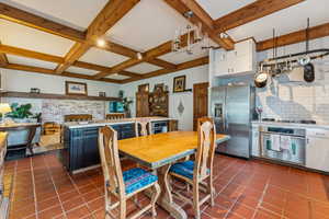 Dining room featuring beamed ceiling, dark tile patterned floors, and coffered ceiling