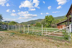 View of yard with a mountain view, an exterior structure, and a view of rural / pastoral area