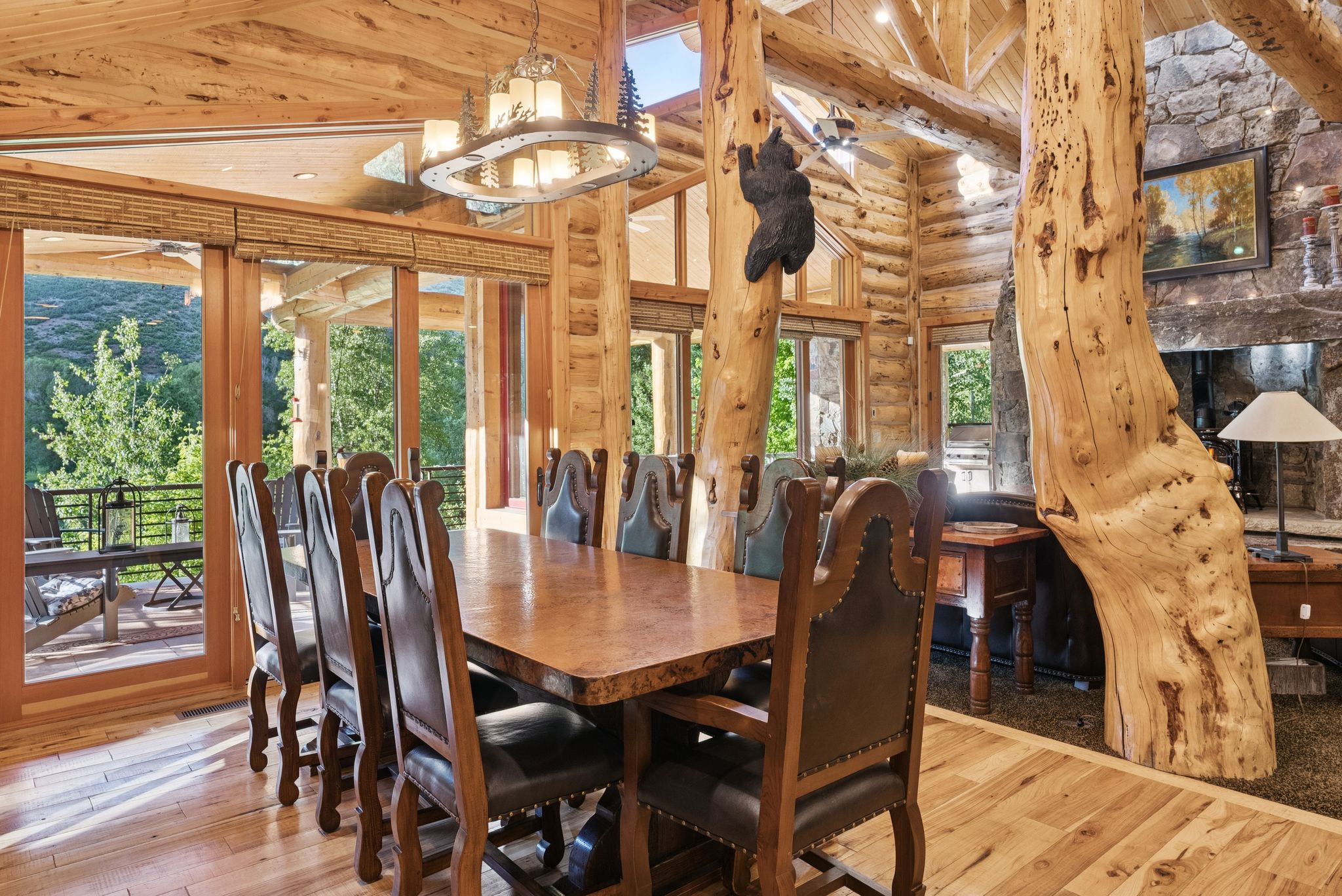 Dining area with high vaulted ceiling, hardwood flooring, rustic walls, a tongue-in-groove ceiling with exposed beams, and a chandelier