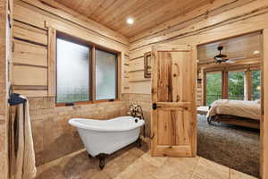 Bathroom with wooden ceiling, a soaking tub, ceiling fan, ensuite bathroom, and recessed lighting