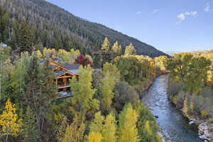 Aerial view of a heavily wooded area and a water and mountain view