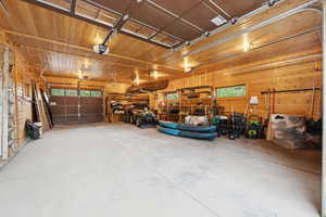 Garage featuring a garage door opener and wooden walls
