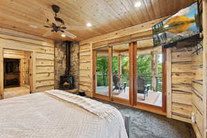 Carpeted bedroom with wooden ceiling, recessed lighting, access to outside, and a wood stove