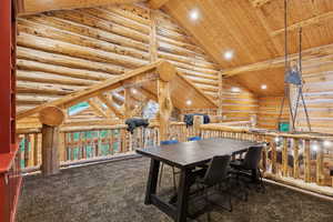 Carpeted dining space with a wooden ceiling with exposed beams, high vaulted ceiling, log walls, and recessed lighting
