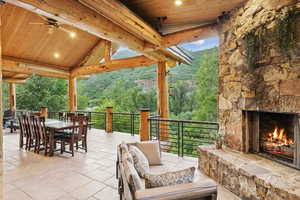 View of patio with outdoor dining space and an outdoor living space with a fireplace