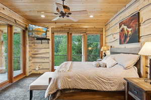 Bedroom with wooden ceiling, access to outside, recessed lighting, wooden walls, and carpet floors