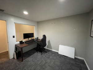 Office space with dark carpet and recessed lighting