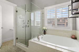 Full bathroom featuring a bath and a shower stall