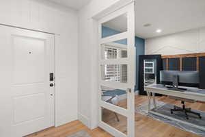 Foyer featuring light wood finished floors and baseboards