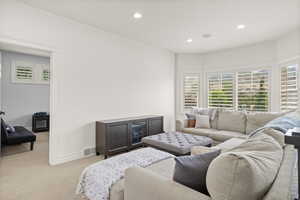 Living room with light carpet and recessed lighting
