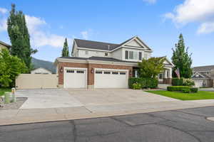 View of front of home with a gate, concrete driveway, brick siding, a mountain view, and a garage