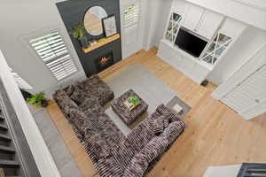 Living area with light wood finished floors, a large fireplace, and healthy amount of natural light