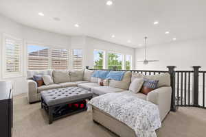 Living area with light colored carpet, recessed lighting, and a ceiling fan