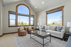 Carpeted living area with a mountain view, recessed lighting, and high vaulted ceiling