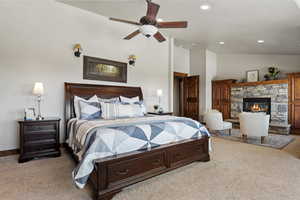 Primary Bedroom with vaulted ceiling, a fireplace, recessed lighting, and a ceiling fan
