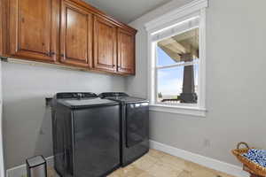 Laundry room with separate washer and dryer and cabinet space