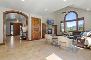 Great Room with arched walkways, a fireplace, recessed lighting, a ceiling fan, and high vaulted ceiling