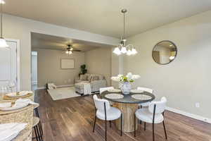Dining area featuring dark wood-type flooring and ceiling fan