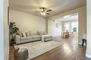 Living area featuring dark wood-style floors and ceiling fan