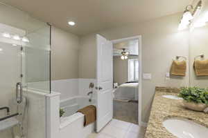 Ensuite bathroom featuring a bath, tile patterned flooring, double vanity, a ceiling fan, and recessed lighting