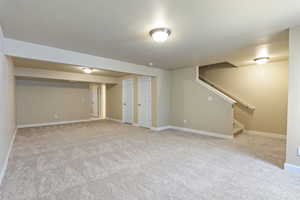 Finished below grade area featuring carpet flooring and stairway