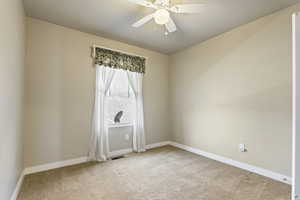 Unfurnished room featuring carpet floors and ceiling fan