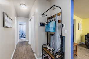 Hallway featuring wood finished floors and baseboards