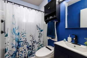 Full bath with vanity and a shower with shower curtain