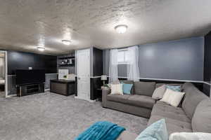 Newly carpeted living room featuring a textured ceiling and baseboards