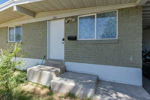 View of exterior entry featuring brick siding