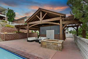View of patio with an outdoor living space with a fire pit and a gazebo
