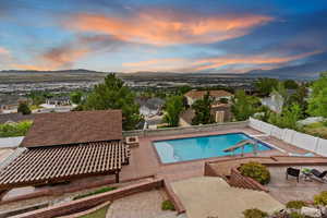 View of swimming pool with a fenced backyard, a mountain view, a patio area, and a residential view