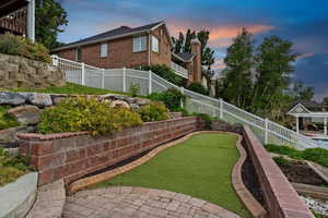 Yard at dusk featuring a putting area and a fenced backyard