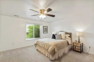 Bedroom with light carpet and a ceiling fan