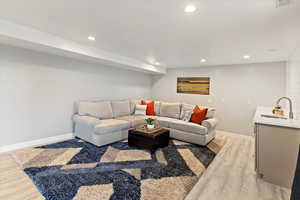 Living room with light wood-style floors and recessed lighting