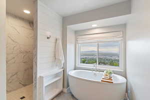 Bathroom featuring a soaking tub, a tile shower, and recessed lighting
