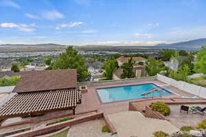 View of swimming pool with a fenced backyard, a mountain view, a patio, and a residential view