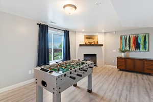 Recreation room featuring light wood-style floors, a fireplace, and recessed lighting