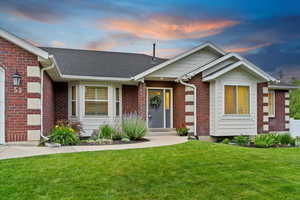 View of front of property with a yard, brick siding, and a shingled roof