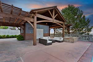 View of patio with an outdoor living space with a fire pit and a pergola