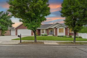 Ranch-style home featuring brick siding, an attached garage, and concrete driveway