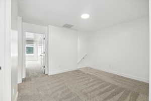 Carpeted spare room with baseboards