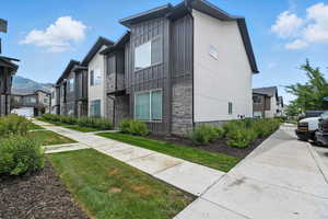 View of side of home featuring stone siding, a residential view, and board and batten siding