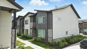 View of front of house with stone siding and board and batten siding