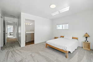 Bedroom with carpet, radiator, connected bathroom, and attic access